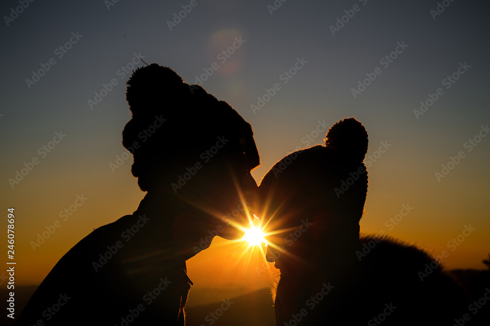 couple in love backlight silhouette on hill at the sunset time