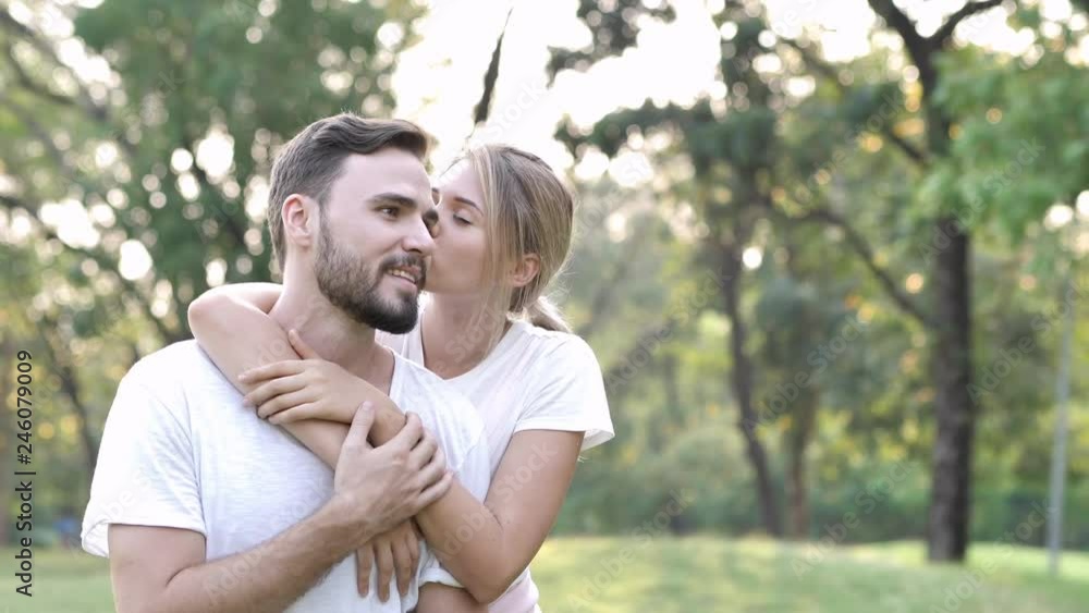 loving young couple kissing in a park on a sunny day. Valentine's day in nature. couple in love concept. Slow Motion loving young couple kissing in a park on a sunny day. Valentine's day in nature. couple in love concept. Slow Motion
