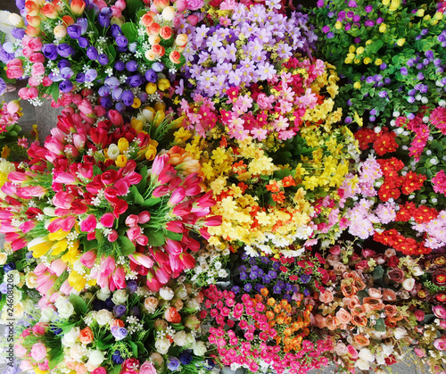 Fototapeta Naklejka Na Ścianę i Meble -  Beautiful multicolored artificial flowers background. flowers decor.