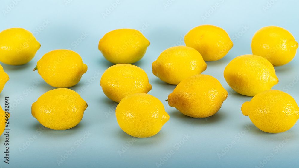 Fresh bright yellow lemons on a blue background Fresh bright yellow lemons on a blue background