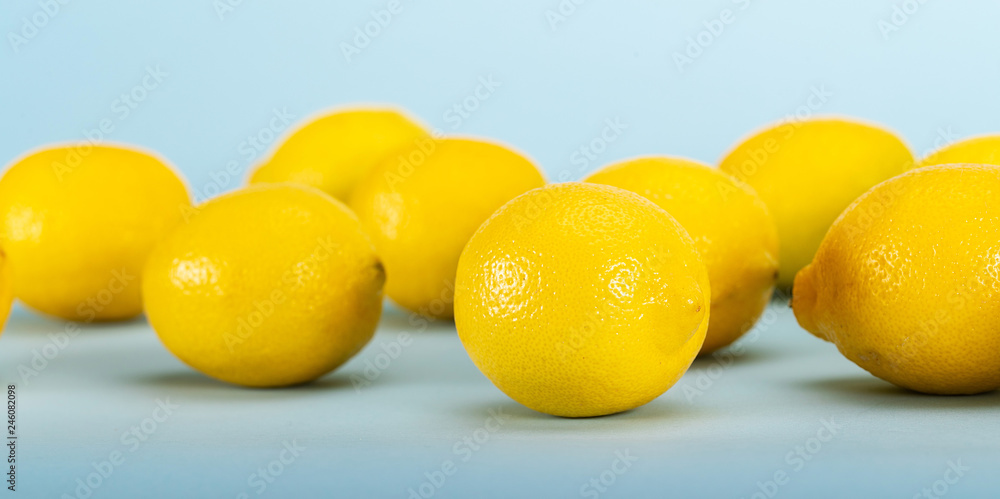 Fresh bright yellow lemons on a blue background Fresh bright yellow lemons on a blue background
