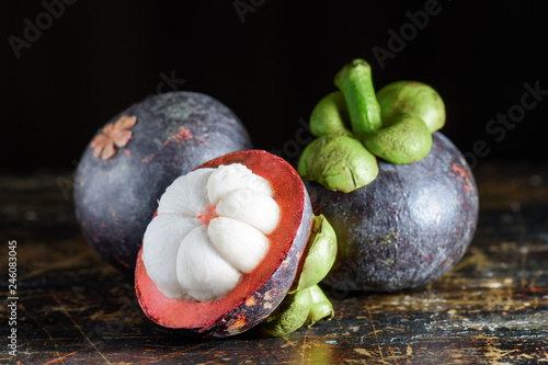 Closeup view of fresh ripe mangosteen on old wooden table