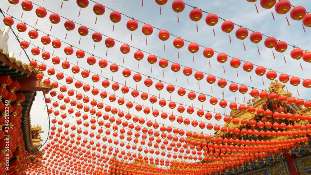 Few rows of red lantern hanging off a buddhist temple structure. Camera ...