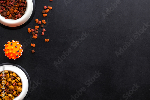 Animal food in bowl on black background top view space for text