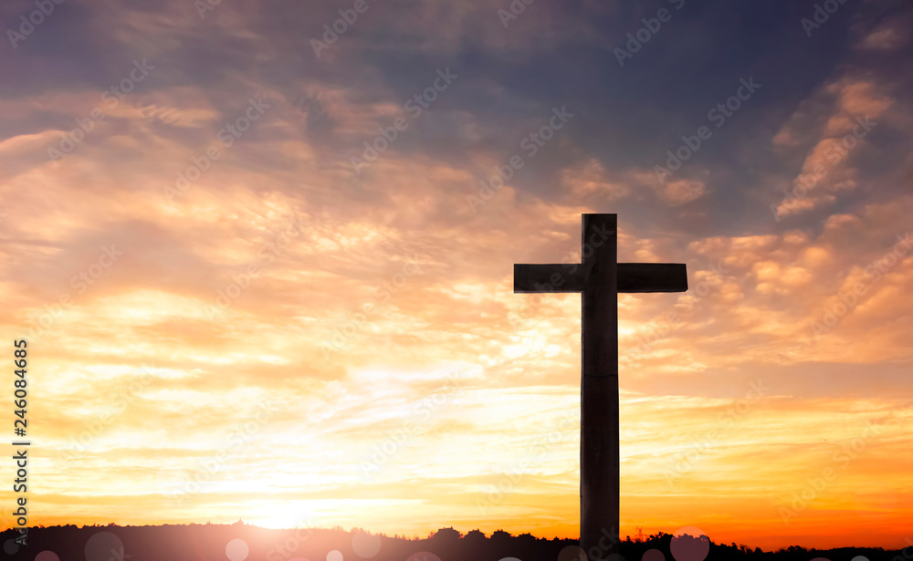 Concept of Jesus Christ: white cross on sunset sky background Concept of Jesus Christ: white cross on sunset sky background