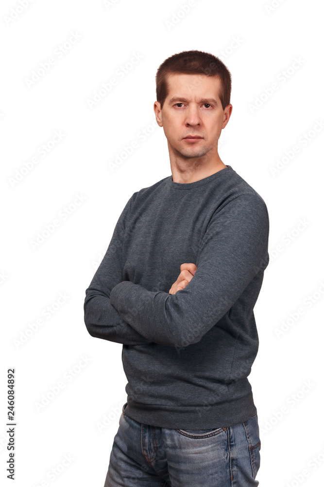 The man in long sleeved t-shirt and jeans crossed hands on a breast The man in long sleeved t-shirt and jeans crossed hands on a breast