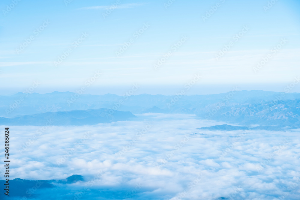 Fototapeta premium Blue sky background with white clouds at the morning.Mist in the morning on the mountain.