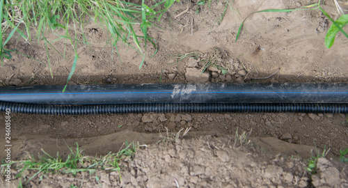 plastic pipe lies in the trench for the supply of communication to the house