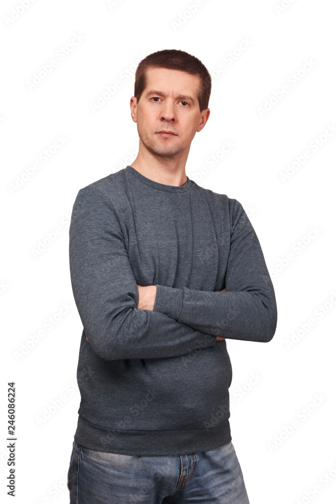 The man in long sleeved t-shirt and jeans crossed hands on a breast The man in long sleeved t-shirt and jeans crossed hands on a breast