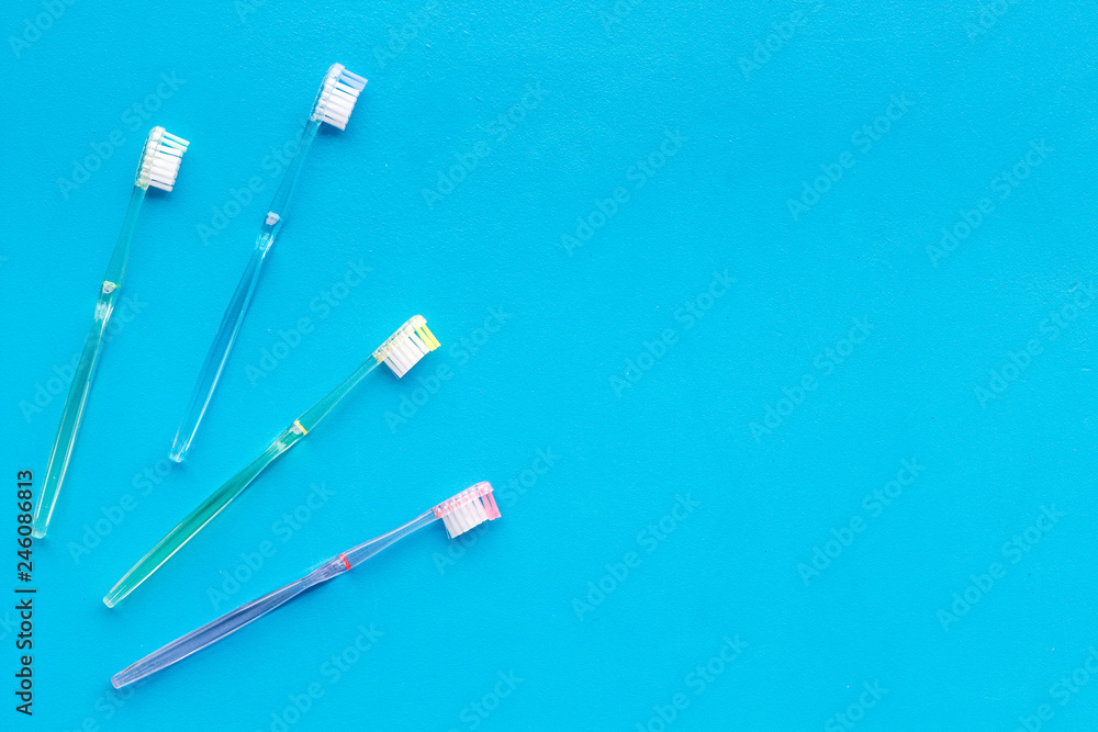 Clean teeth. Plastic toothbrushes on blue background top view copy space Clean teeth. Plastic toothbrushes on blue background top view copy space