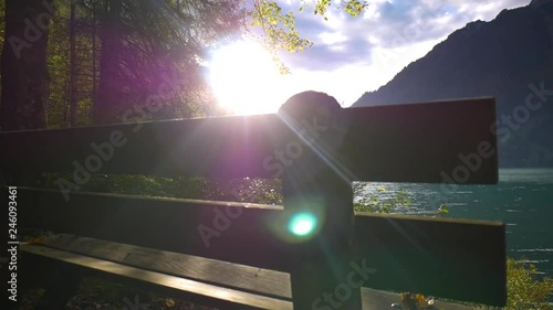 Rising shot over a bench, the sun flares through. In Kl√∂ntal, Switzerland. photo