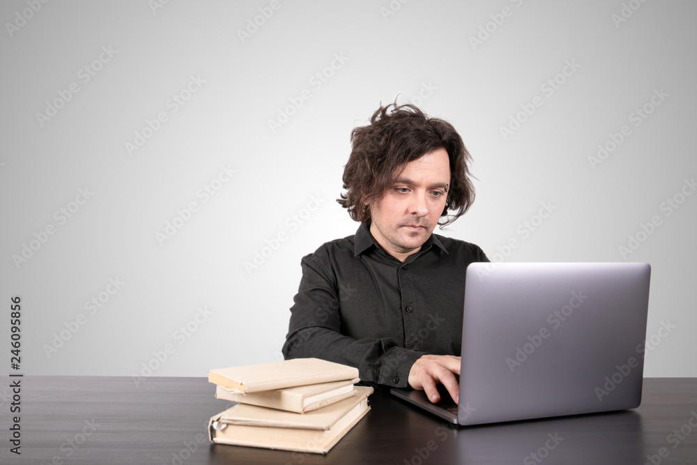 Skills, knowledge and learning online concept. Businessman working on laptop at office. Gray background with copy space Skills, knowledge and learning online concept. Businessman working on laptop at office. Gray background with copy space
