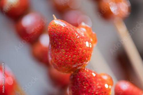 Tanghulu traditional Chinese hard caramel coated strawberry skewers close-up also called bing tanghulu candied hawthorn sticks photo