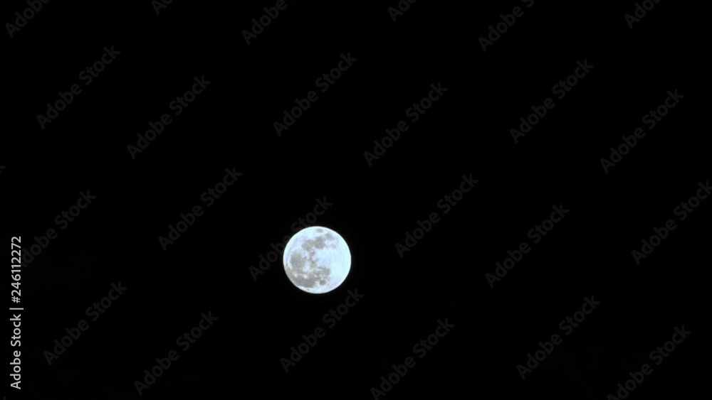 Time lapse view of a full moon in a black cloudy sky Time lapse view of a full moon in a black cloudy sky