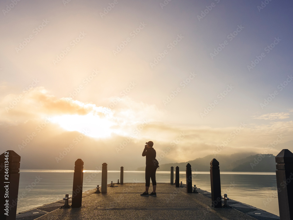 Traveler take picture on pier Lake outdoor sunrise Nature explorer