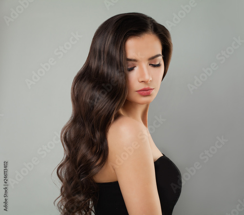 Young brunette model portrait. Perfect woman with long wavy hairstyle