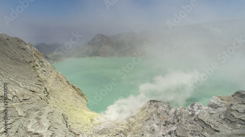 Aerial view mountain landscape with crater acid lake Kawah Ijen where sulfur is mined. Sulfur gas, smoke. Ijen volcano complex group of stratovolcanoes in East Java Indonesia