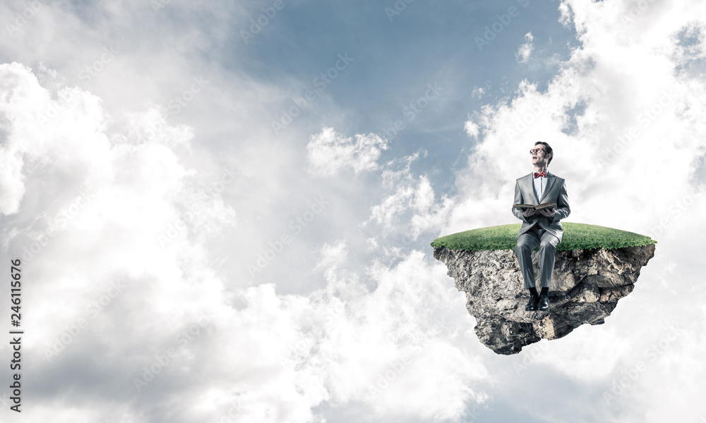 Young businessman or student floating in sky and studying the science Young businessman or student floating in sky and studying the science