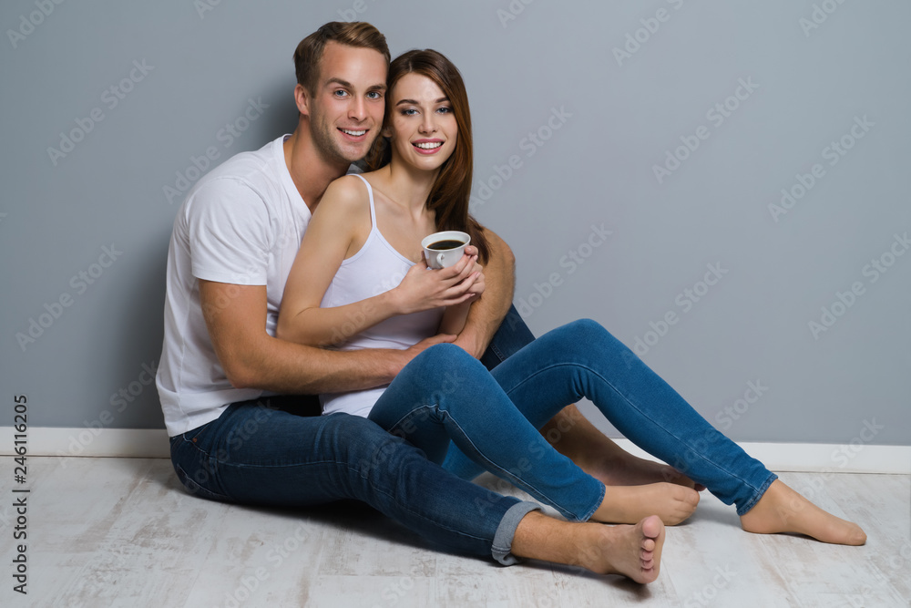 Couple with cup of coffee, sitting on floor Couple with cup of coffee, sitting on floor