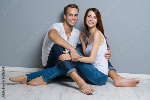 Beautiful young amorous couple, sitting on floor © vgstudio