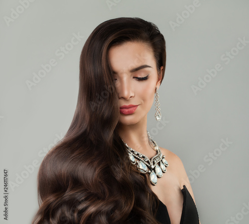 Dark hair woman with makeup, curly and diamond necklace and earrings portrait