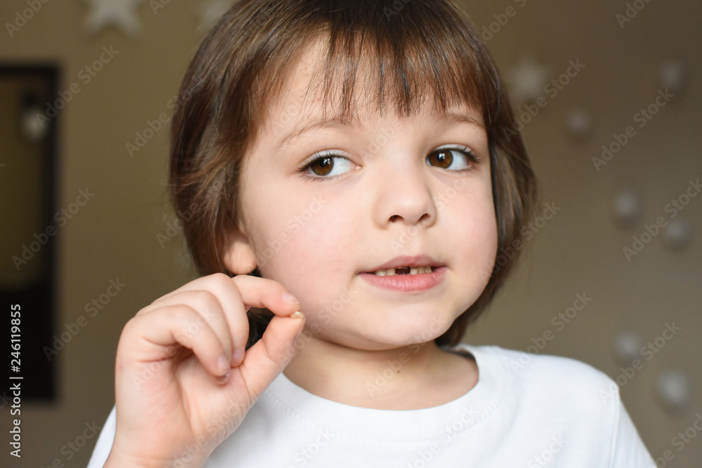 Cute little boy lost first milk tooth. Child showing his milk-tooth that has fallen out Cute little boy lost first milk tooth. Child showing his milk-tooth that has fallen out