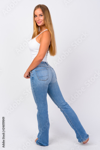 Full body shot of happy young beautiful blonde woman looking back