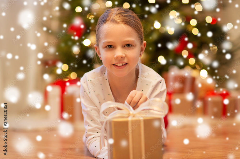 christmas, holidays and childhood concept - smiling girl with gift box at home christmas, holidays and childhood concept - smiling girl with gift box at home