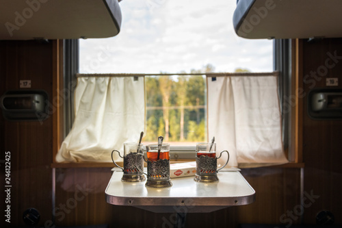 glasses, cups of tea on the table in the train
