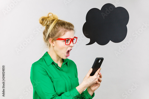 Angry business woman looking at phone, thinking bubble