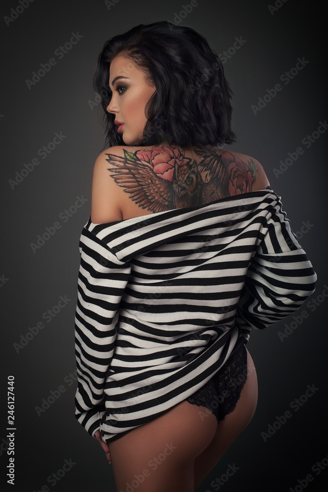 Fototapeta premium young woman in stripped vest on a dark background studio shot