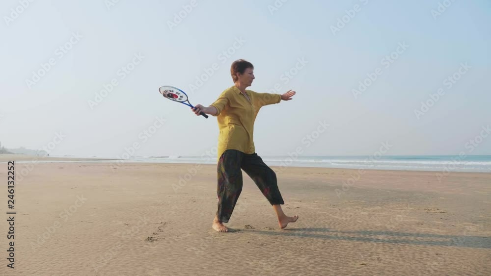 Senior woman practicing tai chi balloon ball on the beach Senior woman practicing tai chi balloon ball on the beach