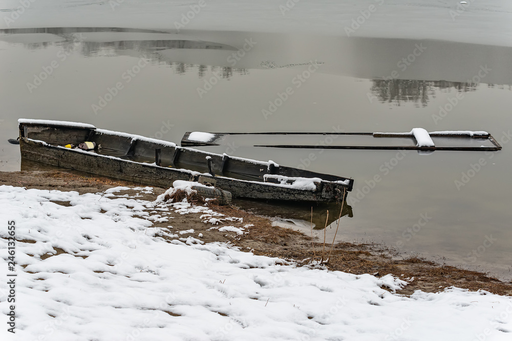 Naklejka premium Beautiful frozen river. A boats covered with snow or submerged.