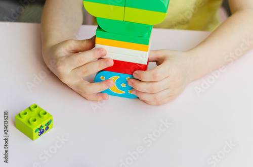 hands of child playing and building with colorful plastic construction toy blocks Kids playing. toys and children. Close up