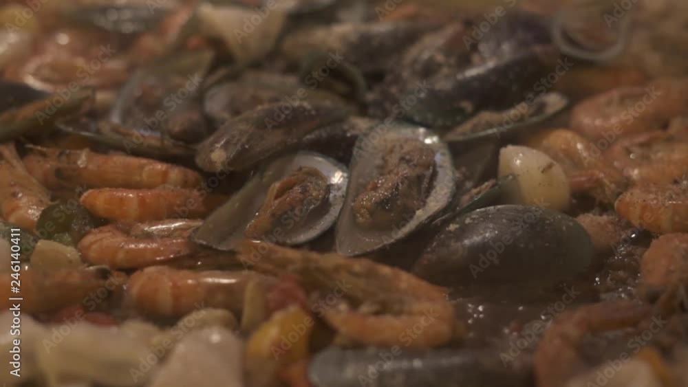Fresh mussels, calamari and shrimps frying in pan. Delicious seafood preparing in restaurant of italian cuisine. Seafood for spanish paella. Food concept. Cooking food closeup. Fresh mussels, calamari and shrimps frying in pan. Delicious seafood preparing in restaurant of italian cuisine. Seafood for spanish paella. Food concept. Cooking food closeup.