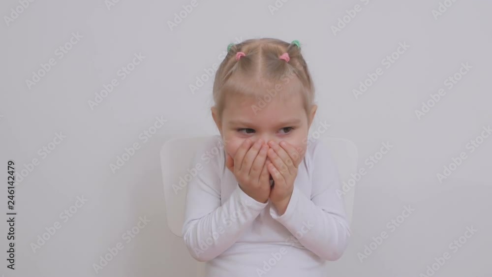 Cute girl two years old emotionally grimacing covers her face with her palms Cute girl two years old emotionally grimacing covers her face with her palms