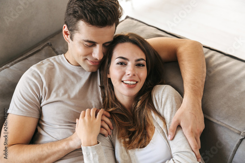 Happy young couple laying on a couch at home
