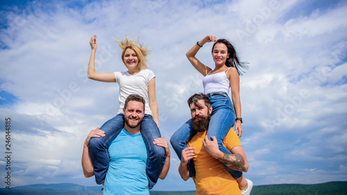 What we would call fun. Happy men piggybacking their girlfriends. Playful couples in love smiling on cloudy sky. Loving couples having fun activities outdoor. Loving couples enjoy fun together