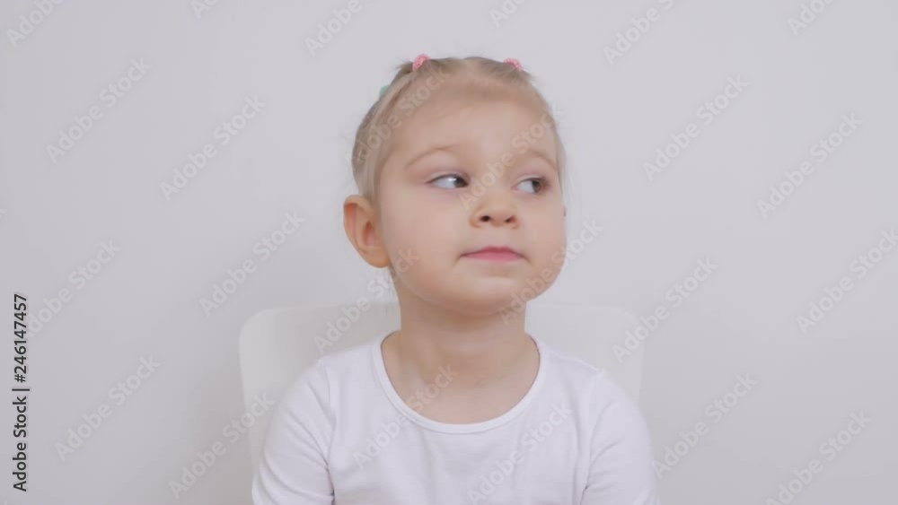 Cute girl two years old looking in front of him sitting on a chair Cute girl two years old looking in front of him sitting on a chair