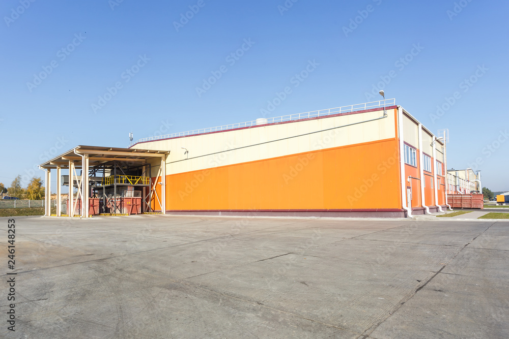 Obraz premium manufacture building of modern waste recycling processing plant in orange style. Separate garbage collection. Recycling and storage of waste for further disposal.