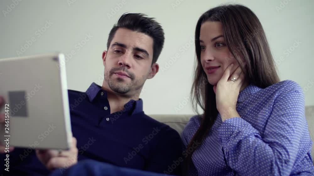 Young couple with tablet moving in a new home, planning how to decorate it. Young couple with tablet moving in a new home, planning how to decorate it.