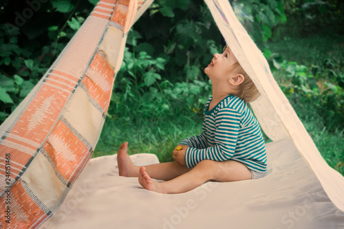 Fotografi Smeared children play in nature in an improvised house