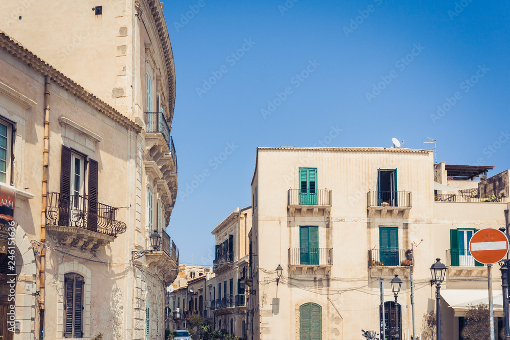View of old street, facades of ancient buildings in seafront of Ortygia (Ortigia) Island, Syracuse, Sicily, Italy.