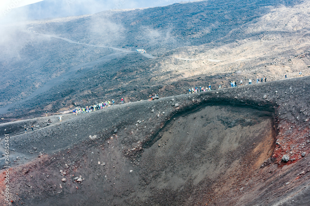 People walking on Mount Etna, active volcano on the east coast of Sicily, Italy.