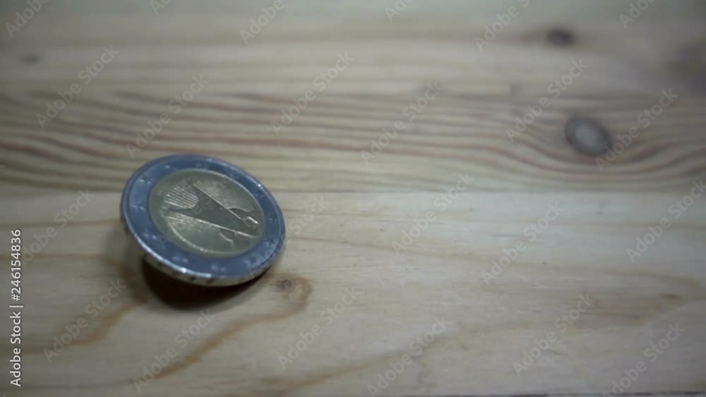Slow motion of euro coin rotation on a wooden table. Slow motion of euro coin rotation on a wooden table.