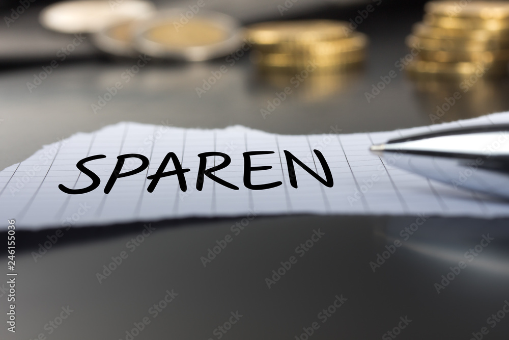 Fototapeta premium Sparen auf einem Zettel mit Stift vor Geldmünzen
