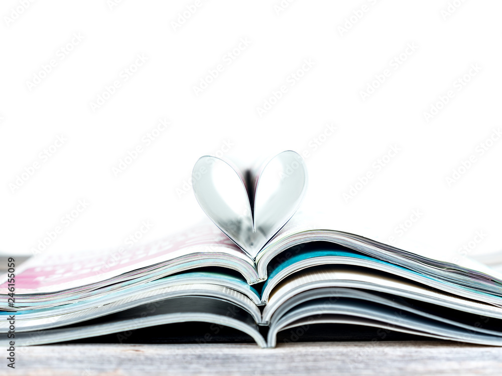 Fototapeta premium Heart shape on stack magazines with white background.