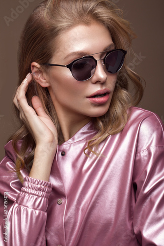 Beautiful girl in stylish pink clothes with sunglasses and sexy lips.