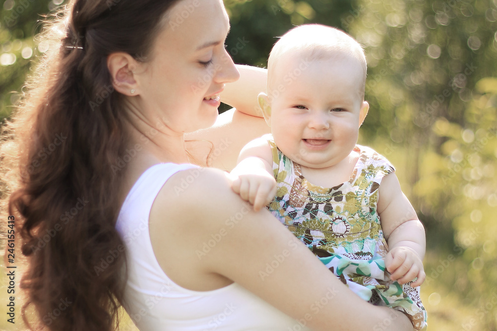 smiling mother and happy one-year-old daughter on a walk in the Park smiling mother and happy one-year-old daughter on a walk in the Park