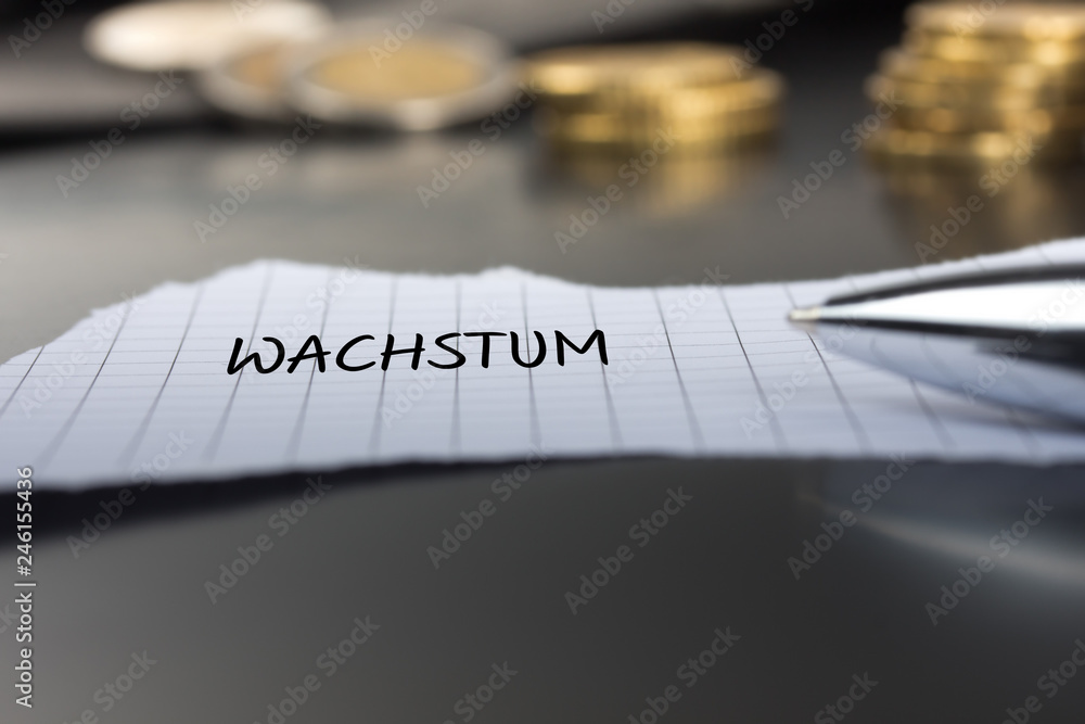 Wachstum auf einem Zettel mit Stift vor Geldmünzen Wachstum auf einem Zettel mit Stift vor Geldmünzen